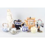 A collection of teapots, including two blue and white teapots, and other items including a white