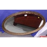 An oval gilt framed wall mirror