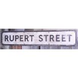 A cast aluminium street sign, "Rupert Street", mounted on a wooden plaque