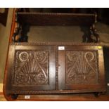 A mid Victorian carved oak wall cupboard enclosed two shell and scroll panelled doors with shelf