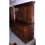 An early 18th century oak dresser, the upper section fitted four "spice" drawers and open shelves