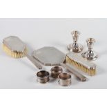 A silver three-piece dressing table set with engine turned decoration, a pair of filled silver