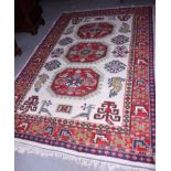 An Indian wool pile rug with three octagonal guls on a cream ground, 99" x 66" approx