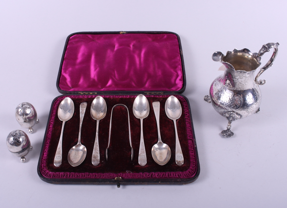 A silver cream jug with scroll handle, on shell feet, a boxed set of six silver teaspoons and a pair