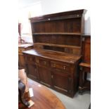 An early 18th century oak dresser, the upper section fitted four "spice" drawers and open shelves