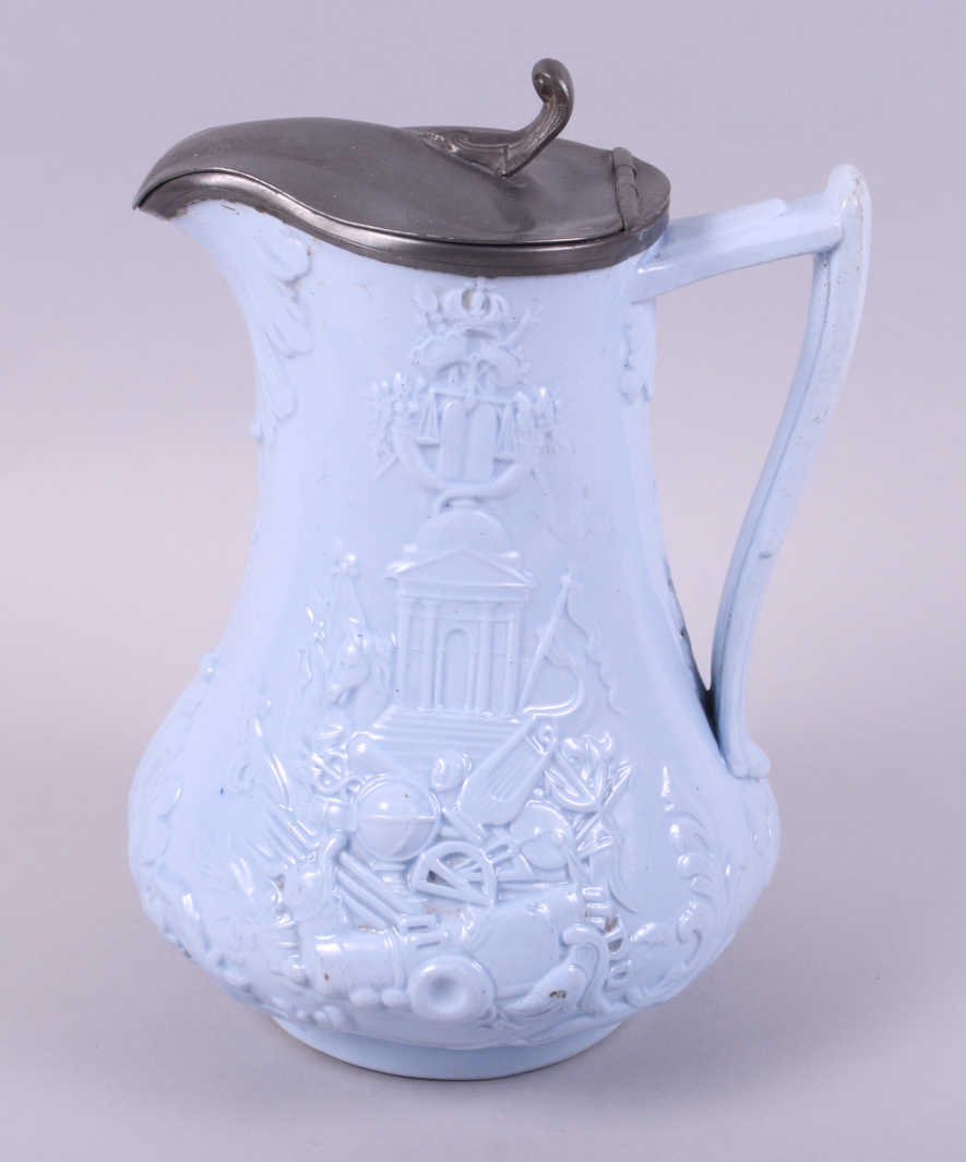 A 19th century blue glazed relief moulded jug, decorated exotic animals and war trophies (Europe and