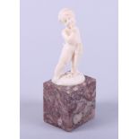 A 19th century ivory figure of an Amorini, on marble base, 4 1/4" high