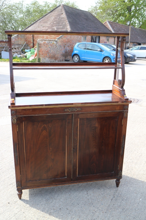 An early 19th century rosewood and gilt brass mounted chiffonier with two open shelves over