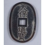 An oval Oriental coin with pierced centre and character marks