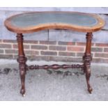 A late Victorian walnut kidney-shape writing table with lined top, on turned and carved splay