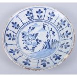 An 18th century English delft dish with floral decoration, 9" dia (fritting and chip to rim)