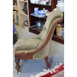 A Victorian walnut 'S' scroll showframe low seat nursing chair, button upholstered in a green