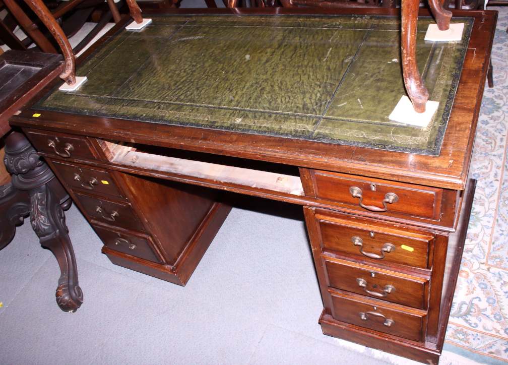 A partners Victorian mahogany double pedestal desk with tooled green leather lined top, fitted seven