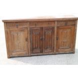 A carved oak side cupboard, fitted three drawers over cupboards enclosed linen fold doors, 63" wide
