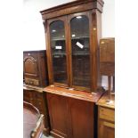 A Victorian walnut book case with glazed upper section over cupboards enclosed arch top panel doors,