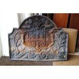 A cast iron fire back of 17th century design with coat of arms, 28" wide, and a cast iron grate,