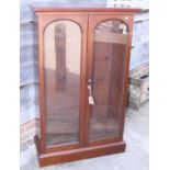 A 19th century mahogany bookcase, fitted adjustable slides enclosed two arch top glazed panel doors,