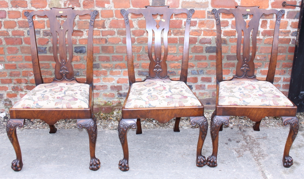 A set of three Irish caved walnut side chairs with pierced splats and drop-in seats, on shell carved