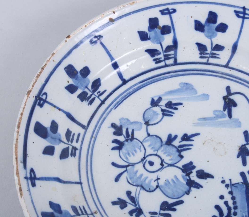 An 18th century English delft dish with floral decoration, 9" dia (fritting and chip to rim) - Image 3 of 5