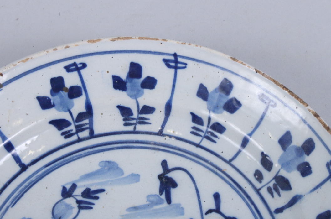 An 18th century English delft dish with floral decoration, 9" dia (fritting and chip to rim) - Image 4 of 5