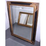 An ebonised and gilt framed wall mirror, in deep swept frame, plate 23" x 35"