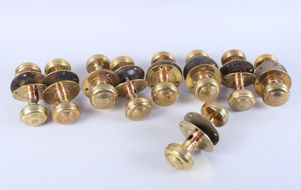 A set of nine pairs of early 19th century brass and copper doorknobs with spindles