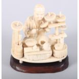 A late 19th century Japanese sectional ivory figure of a craftsman at work, 3 1/2" high on oval