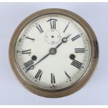 A metal cased wall clock with brass cover, white enamel dial and Roman numerals
