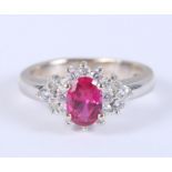 A white metal (stamped 750), ruby and diamond cluster ring, size J, 4.5g