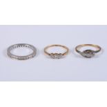 An 18ct white gold and diamond full eternity ring, size Q, and two 18ct gold and diamond three stone