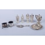 A silver three-piece cruet set, a pair of silver pepper pots, a pair of silver salts, a silver bread