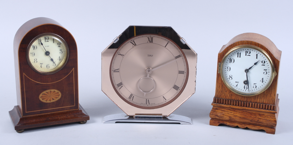 An Edwardian mahogany and inlaid mantel clock, an oak cased mantel clock and a modern Temco electric