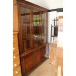 A walnut bookcase of Georgian design, the upper section enclosed three lattice glazed doors over