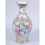 A Canton enamel vase with figure decorated panels and flared rim, 9" high