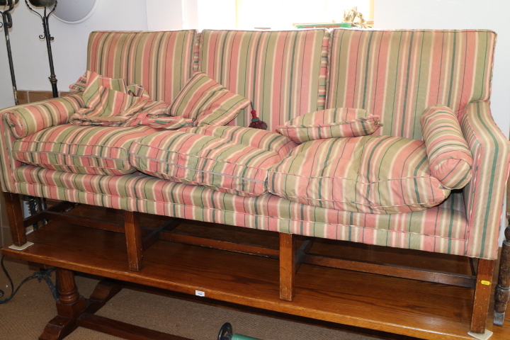 A mahogany framed settee of Georgian design, upholstered in a striped fabric, on moulded,