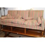 A mahogany framed settee of Georgian design, upholstered in a striped fabric, on moulded,