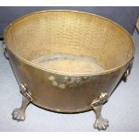 A brass oval two-handle log bin with lion paw feet, 17" wide