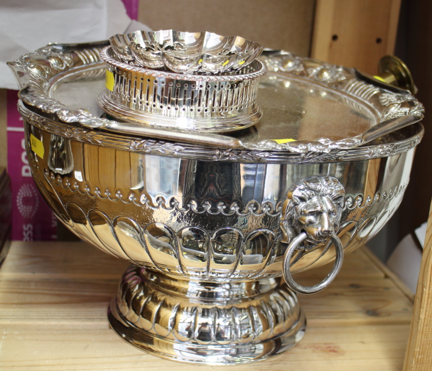 A collection of silver plate, including a punch bowl with lion mask ring handles, a tray with