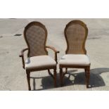 A set of eight carved polished as walnut shaped cane back dining chairs with stuffed over seats,