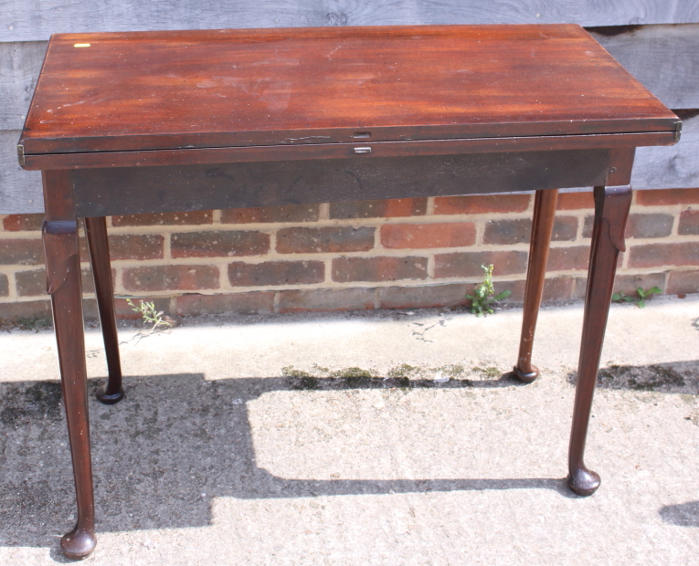 A 19th century mahogany fold-over top tea table, on pole turned supports and pad feet, 35" wide