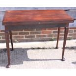 A 19th century mahogany fold-over top tea table, on pole turned supports and pad feet, 35" wide