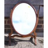 An oval swing frame toilet mirror, on skeleton stand, 19 1/2" wide