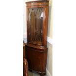 A mahogany corner display cabinet, the upper section enclosed lattice glazed door over cupboard,