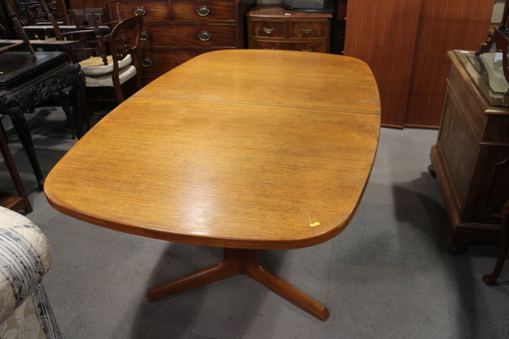 A mid 20th century Danish teak extending dining table, with two leaves, a set of eight matching