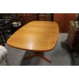 A mid 20th century Danish teak extending dining table, with two leaves, a set of eight matching