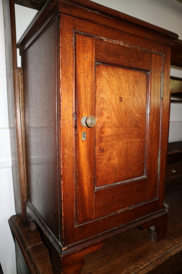 A mahogany bedside cabinet enclosed one door, on bracket feet, 16" wide