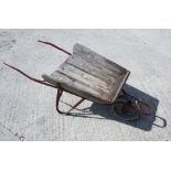 A red painted wrought iron framed vintage wheelbarrow