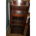 An oak bookcase, fitted open shelf over leaded glazed doors, 15" wide