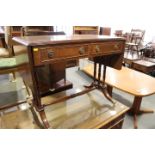 A mahogany and banded sofa table of Regency design, on triple spindle end supports with brass lion