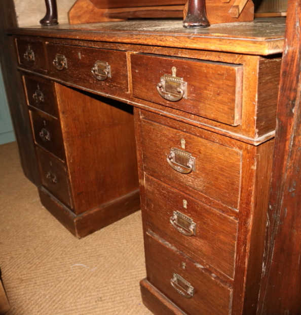 An oak double pedestal desk with green leather top over nine drawers, on block base, top 48" x 22"